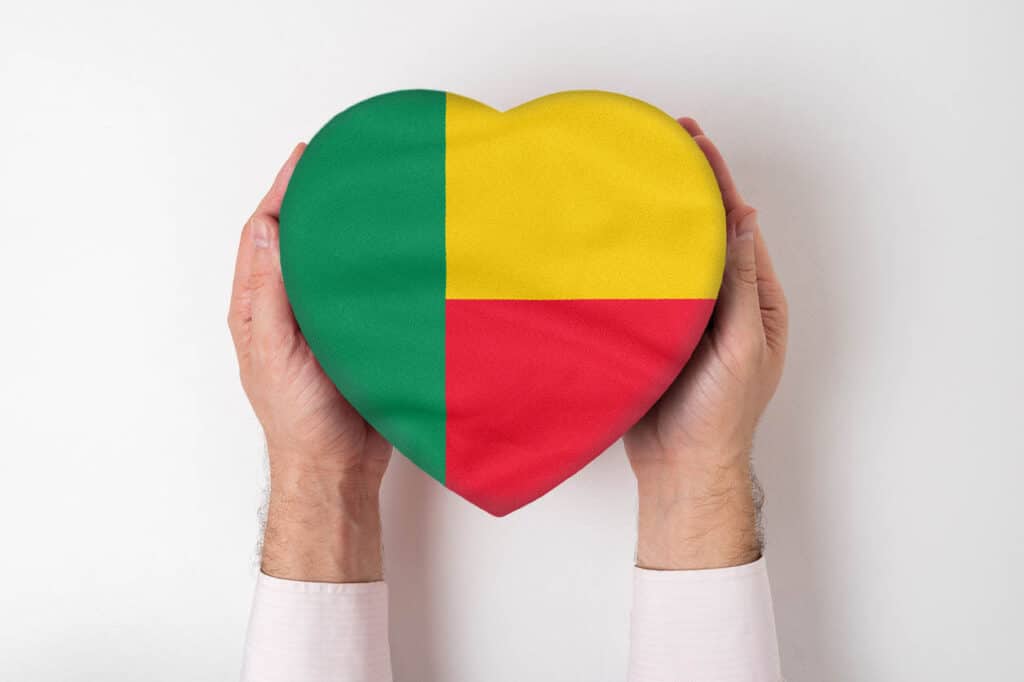 Flag Of Benin On A Heart Shaped Box In A Male Hands. White Background