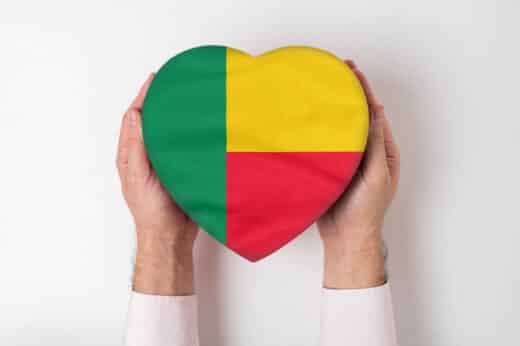 Flag Of Benin On A Heart Shaped Box In A Male Hands. White Background
