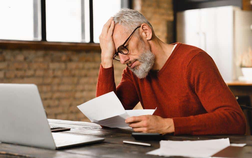 Homme Qui Se Tient La Tête En Voyant Des Frais D'obsèques